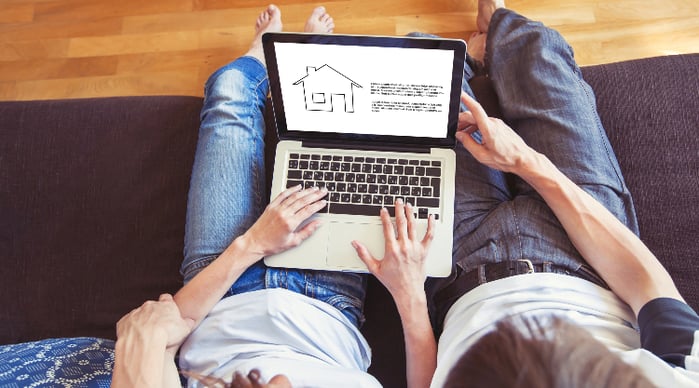 couple with laptop and real estate information