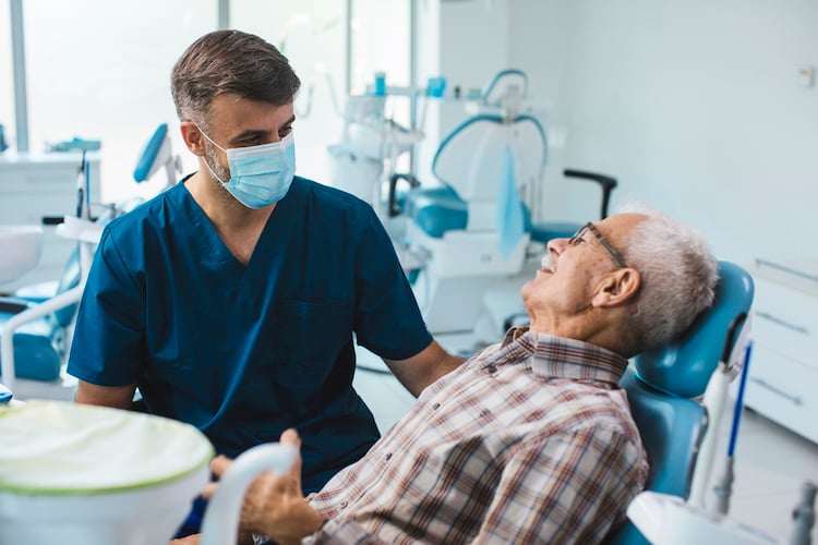 male dentist examining patient