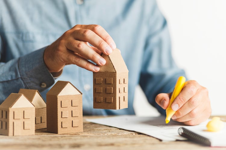 real estate investor with cardboard houses