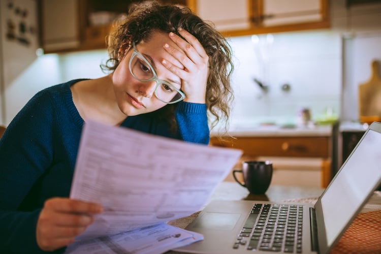 woman going through bills looking worried